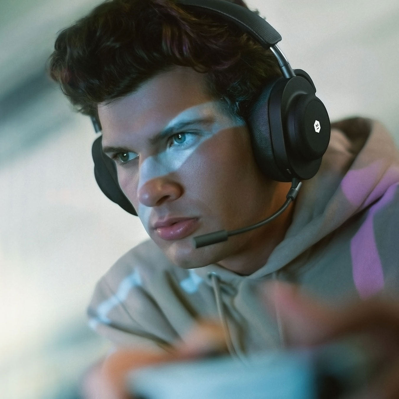 Man holding a video game controller wearing onyx black MG20 Wireless Gaming Headphones | gallery MG20B1