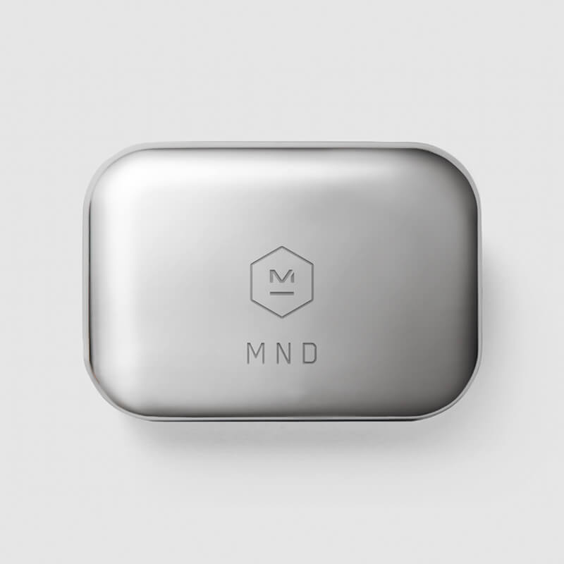 Top down image of a stainless steel MW07 True Wireless Earphones case featuring Master & Dynamic logo and custom engraving with the letters M N D | gallery C0001