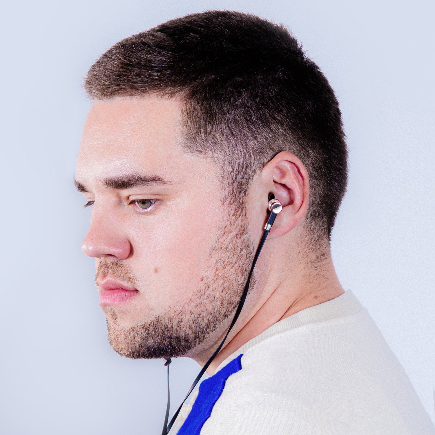 Profile of a man with brown hair and a white shirt wearing wired palladium and black ME05 Earphones | gallery ME05PD-MK2