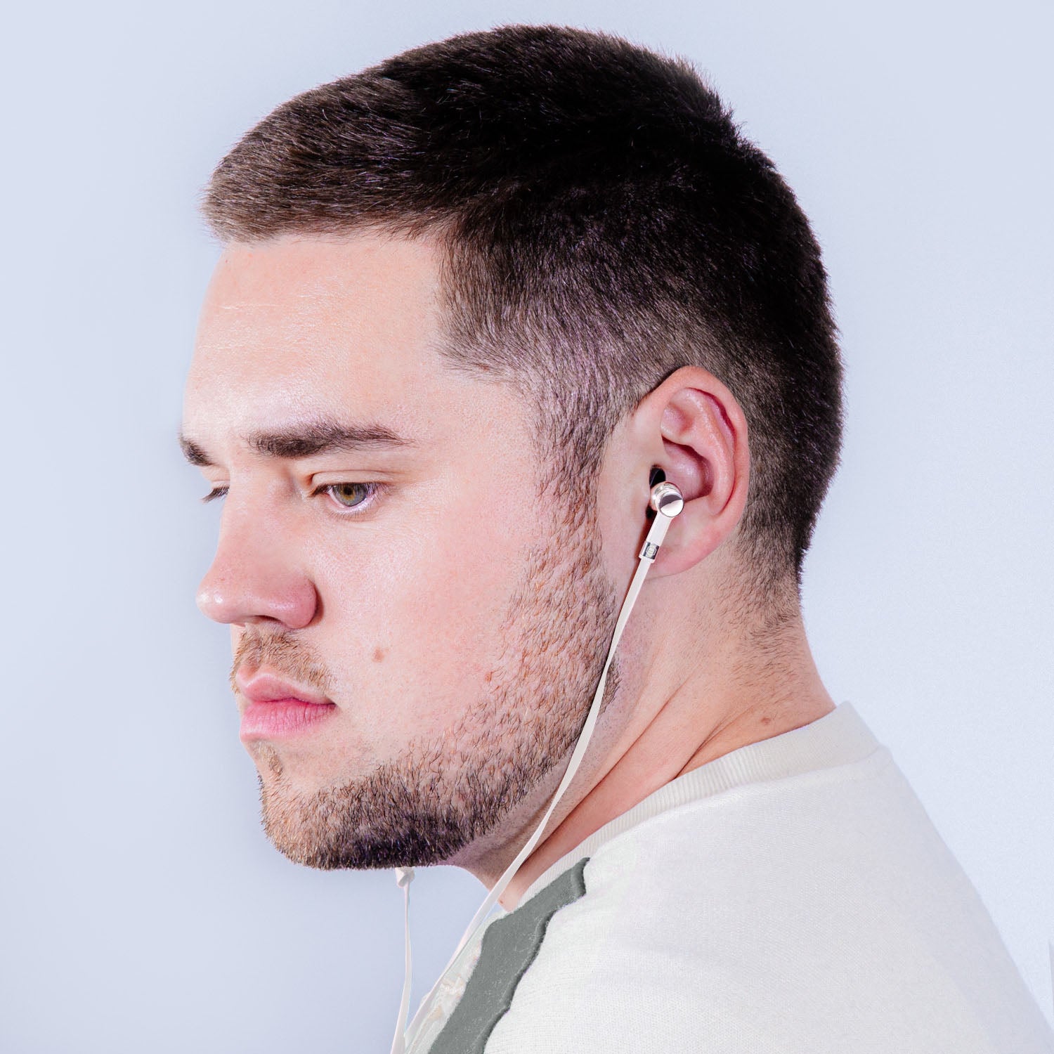 Profile of a man with brown hair and a white shirt wearing wired palladium and white ME05 Earphones | gallery ME05WT-MK2