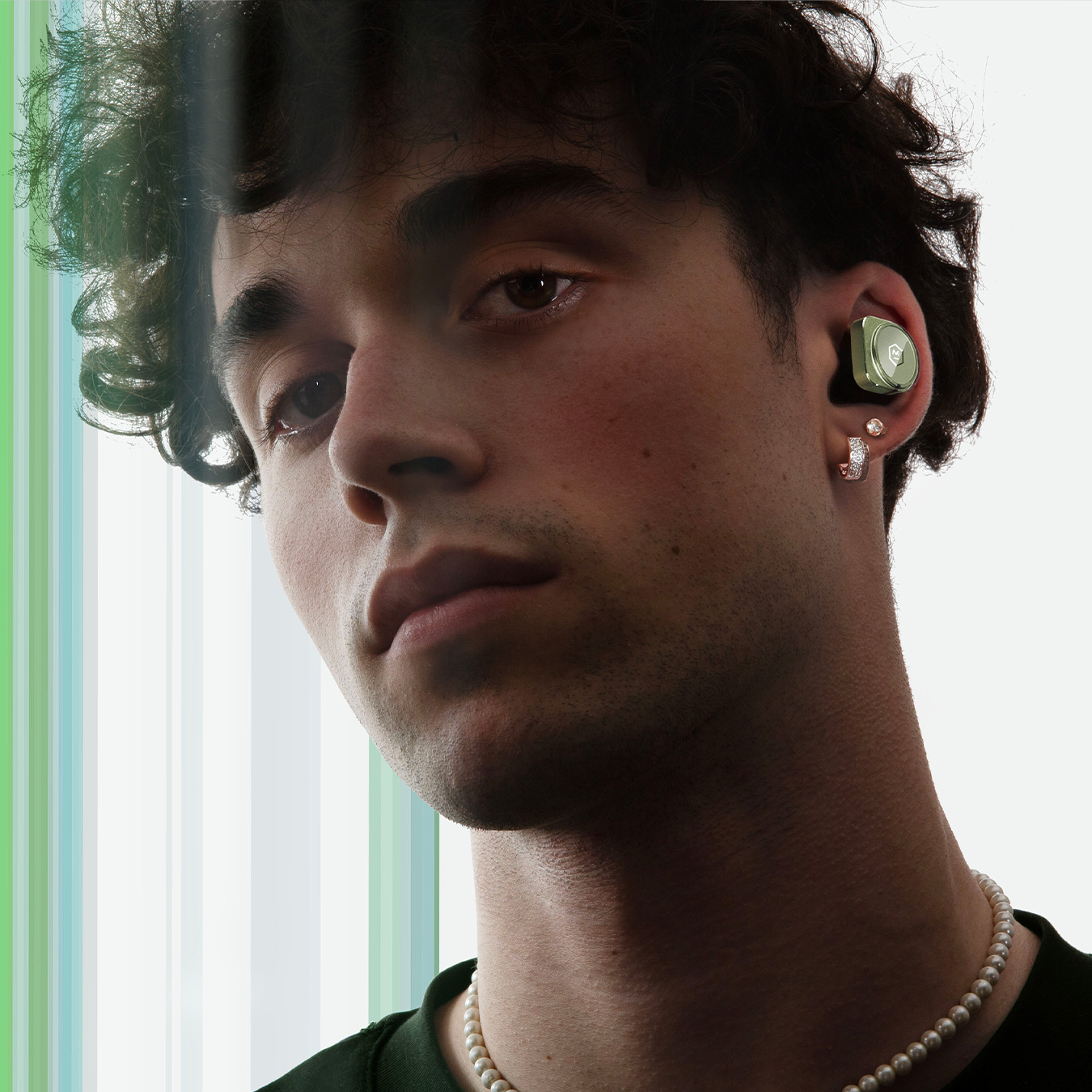 Man with brown hair wearing green MW09 True Wireless Earphones against a white background with green stripes | gallery MW09GR9