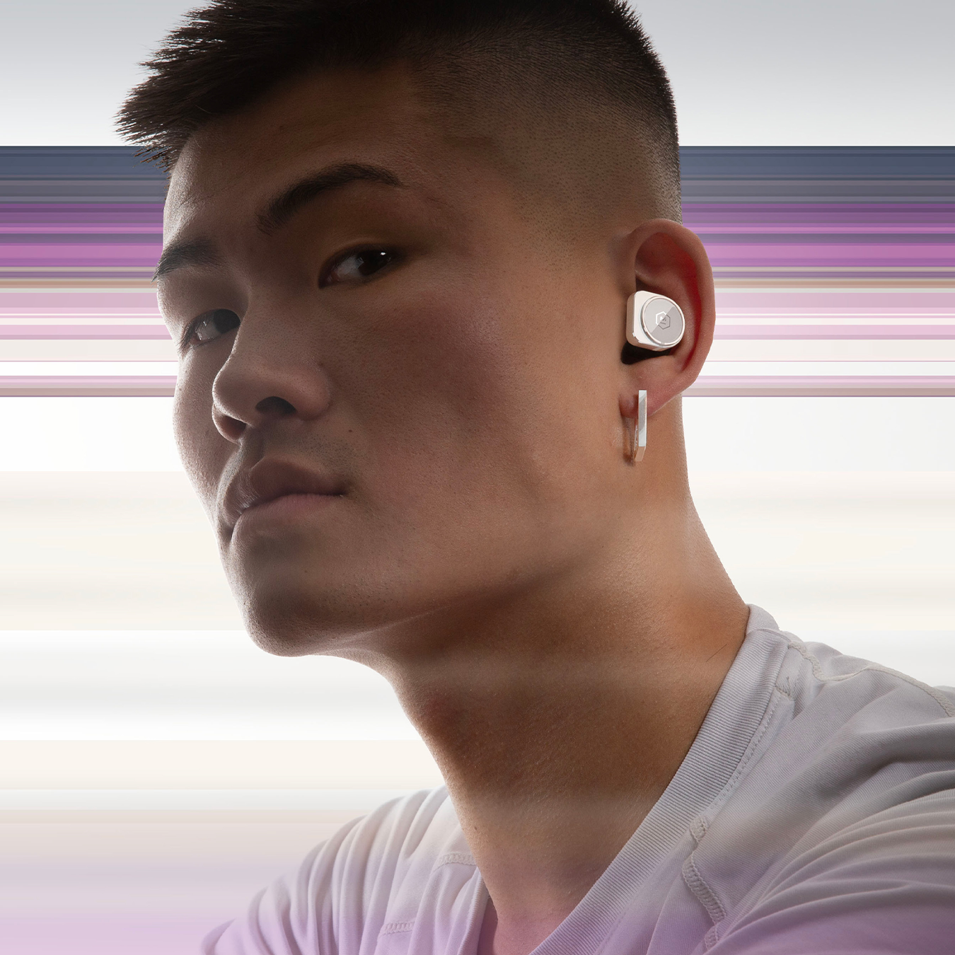Man in a white t-shirt wearing silver and white MW09 True Wireless Earphones against a purple striped background | gallery MW09S5