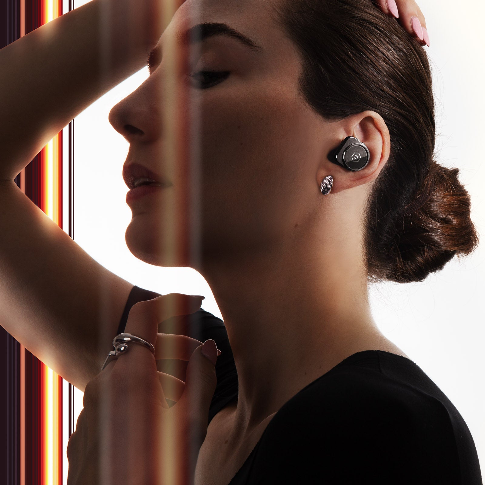 Profile of woman with brown hair wearing black MW09 True Wireless Earphones against a black background with red stripes | gallery MW09BK1