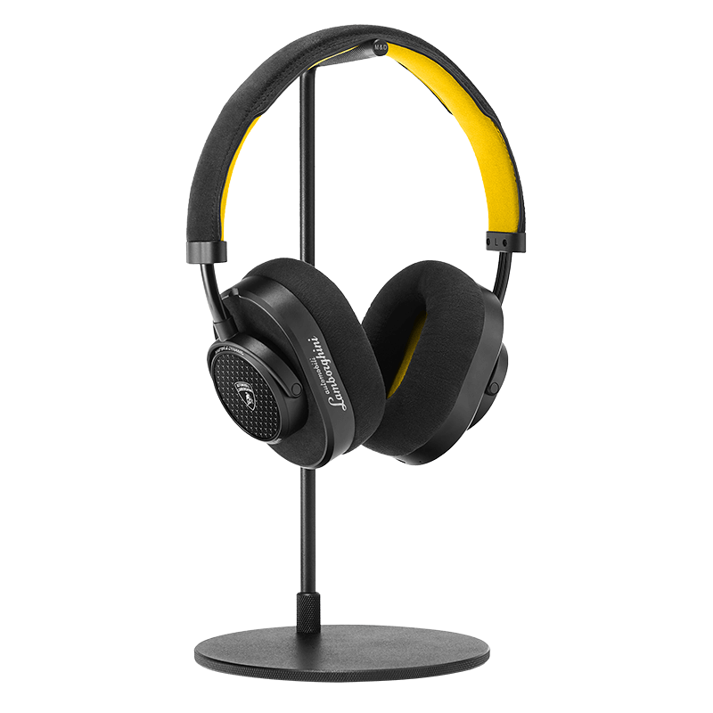 Black leather and metal MW65 Wireless headphones with Automobili Lamborghini on the ear cup placed on a black headphone stand showing inner yellow Alcantara headband and ear pads  | gallery MW65-LAM2